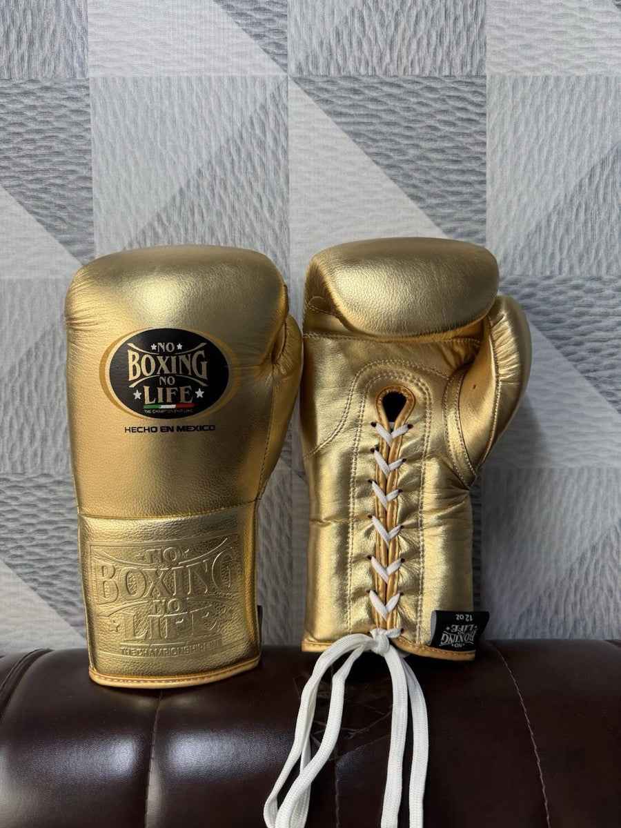 Pair of professional 12 oz No Boxing No Life metallic gold lace-up boxing gloves featuring traditional white laces and "Hecho en Mexico" branding at PunchPro Boxing.