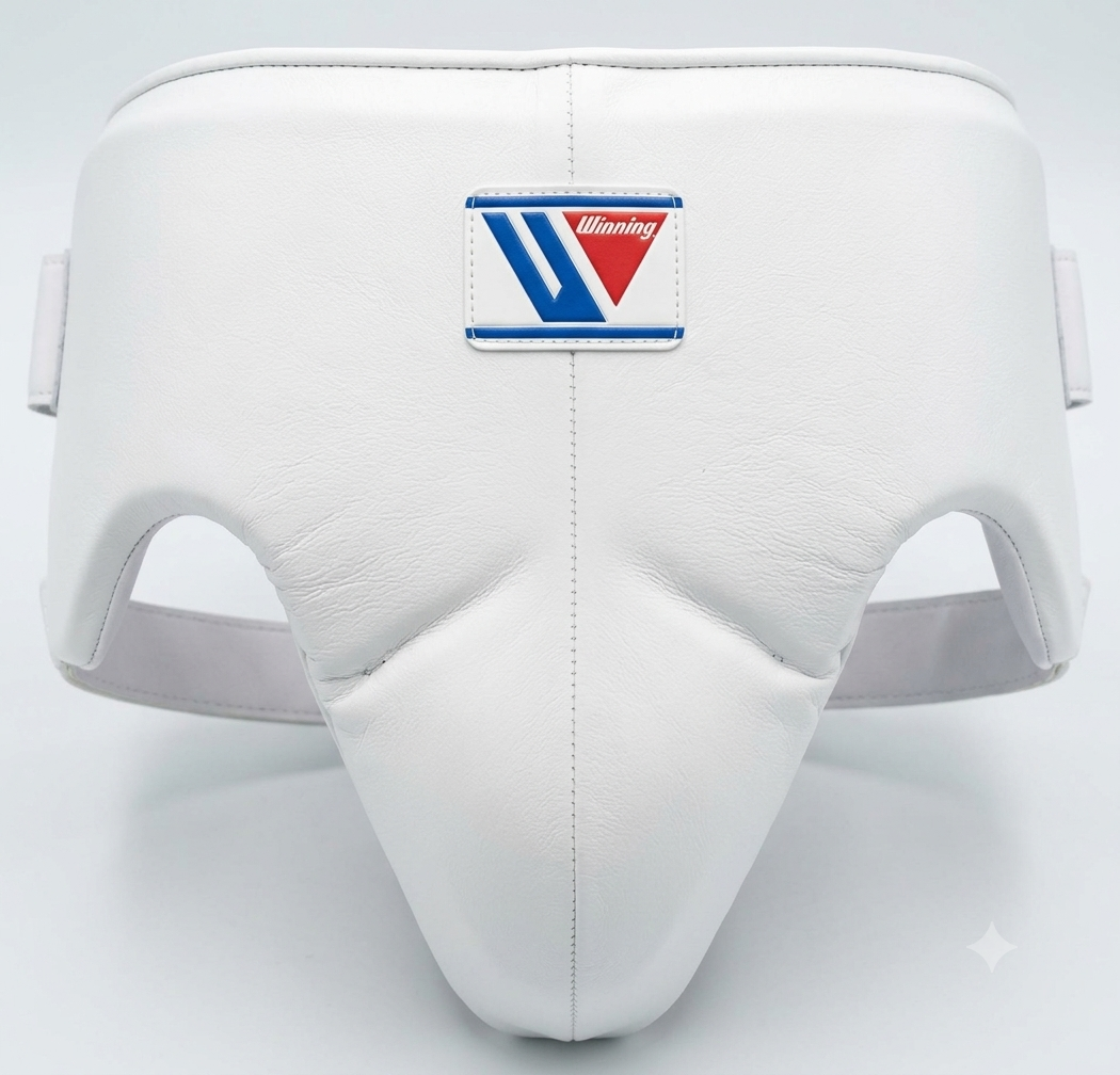 White leather martial arts shin guard with a central logo patch featuring blue and red details, photographed on a light gray background.