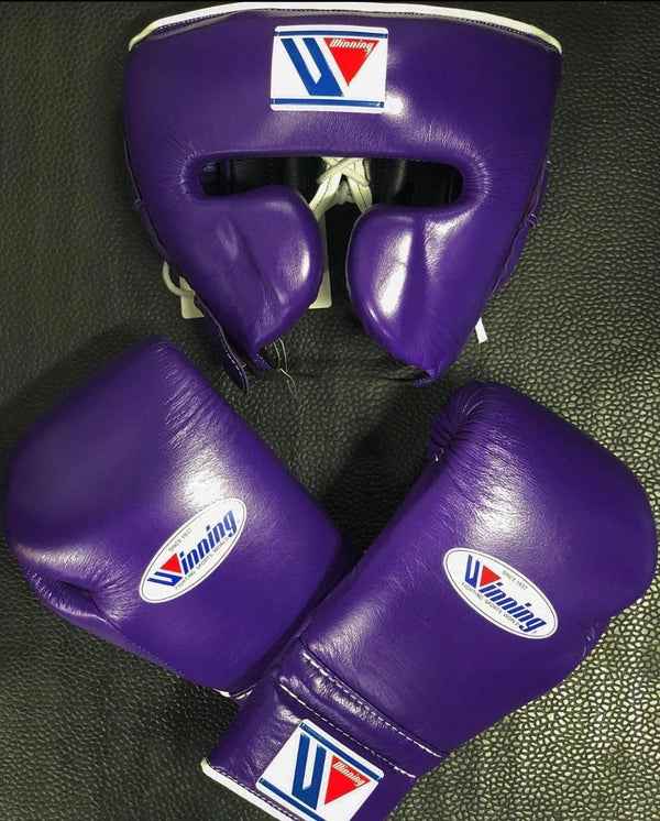 Complete Winning professional purple training set including lace-up gloves and matching face guard on a black leather background at PunchPro Boxing.