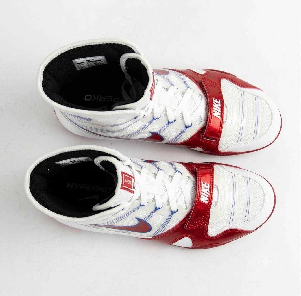 A pair of Nike Hyperko boxing shoes in white, red, and blue, displayed on a light gray background.