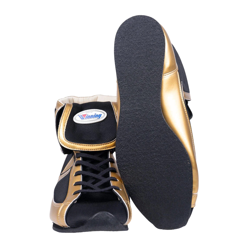 Black and gold boxing shoes showing side profile and textured rubber outsole